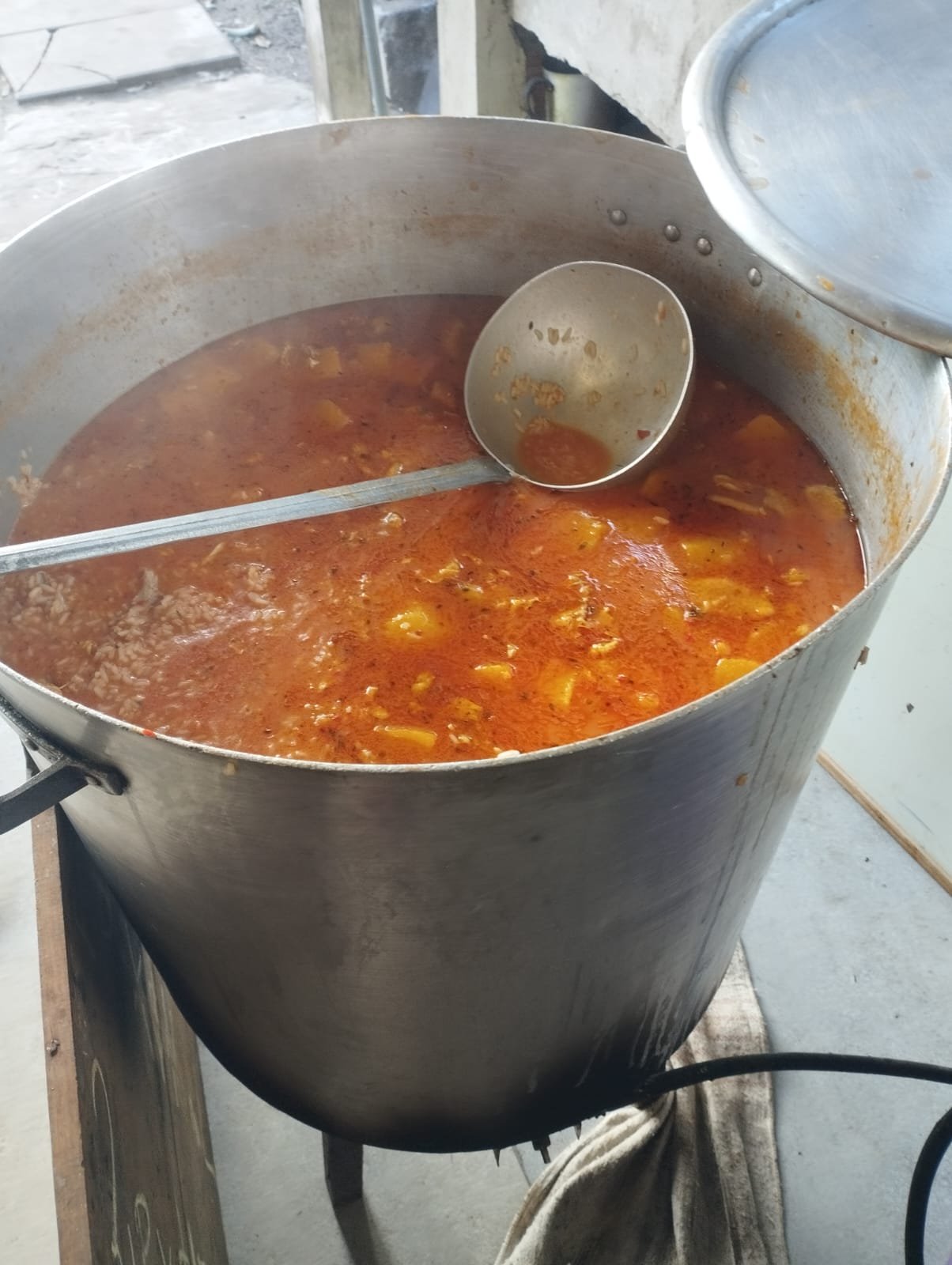 Olla grande de guiso revolviéndose sobre el fuego